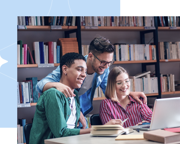 Três jovens em uma biblioteca, sorrindo olhando para o computador.